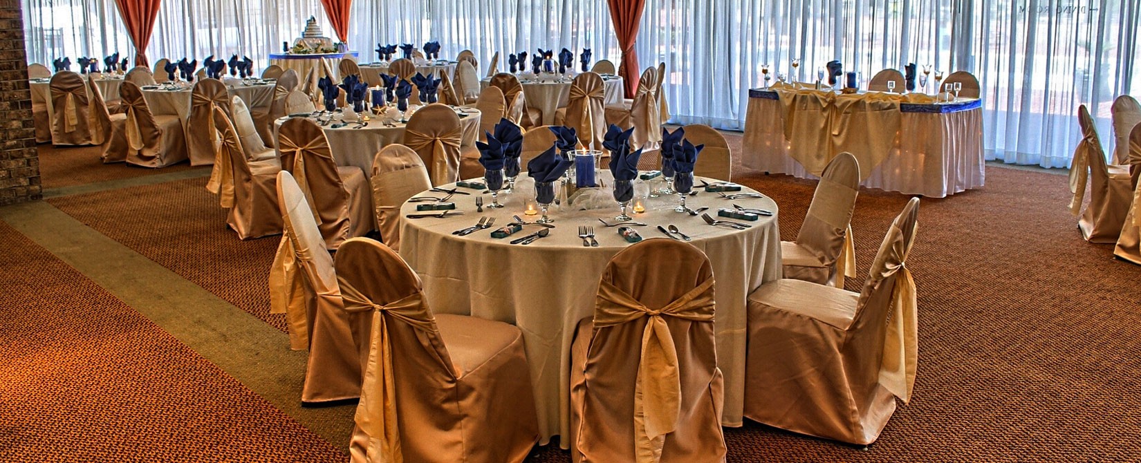 gold and navy wedding place settings and chair wraps at The Caravelle Resort