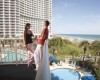 Couple enjoying coffee on a balcony at Sea Watch overlooking the pool and the ocean