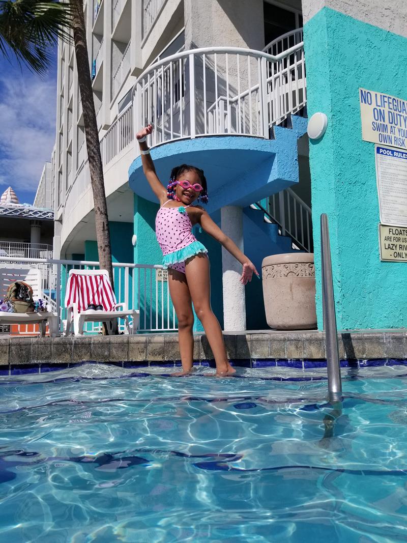 girl standing on pool steps at crown reef resort