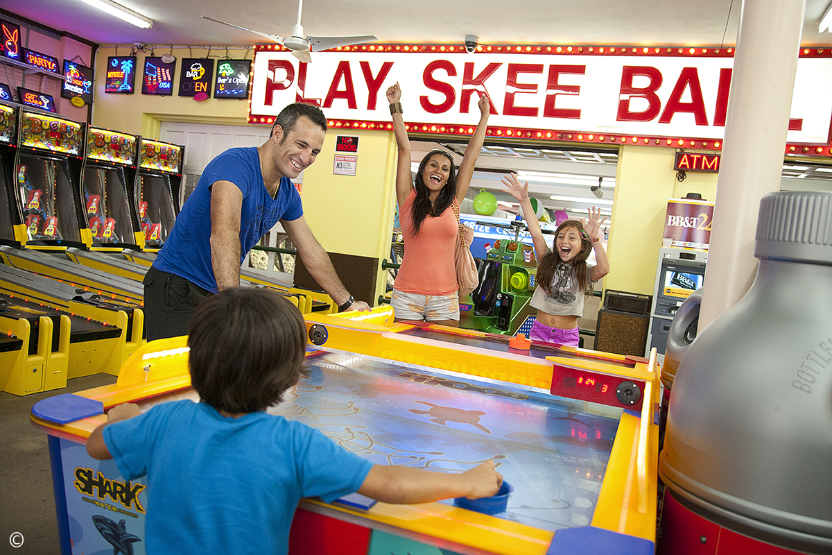 family playing air hockey at arcade