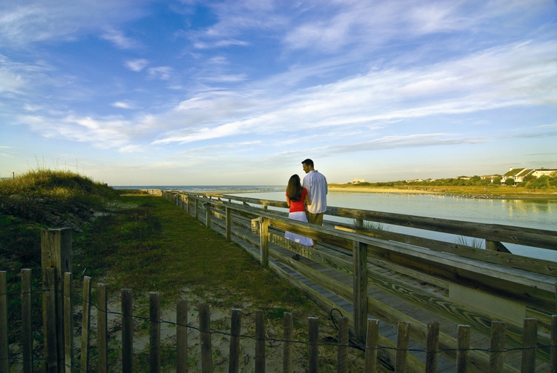 romantic couple taking a stroll on the ocean creek resort boardwalk