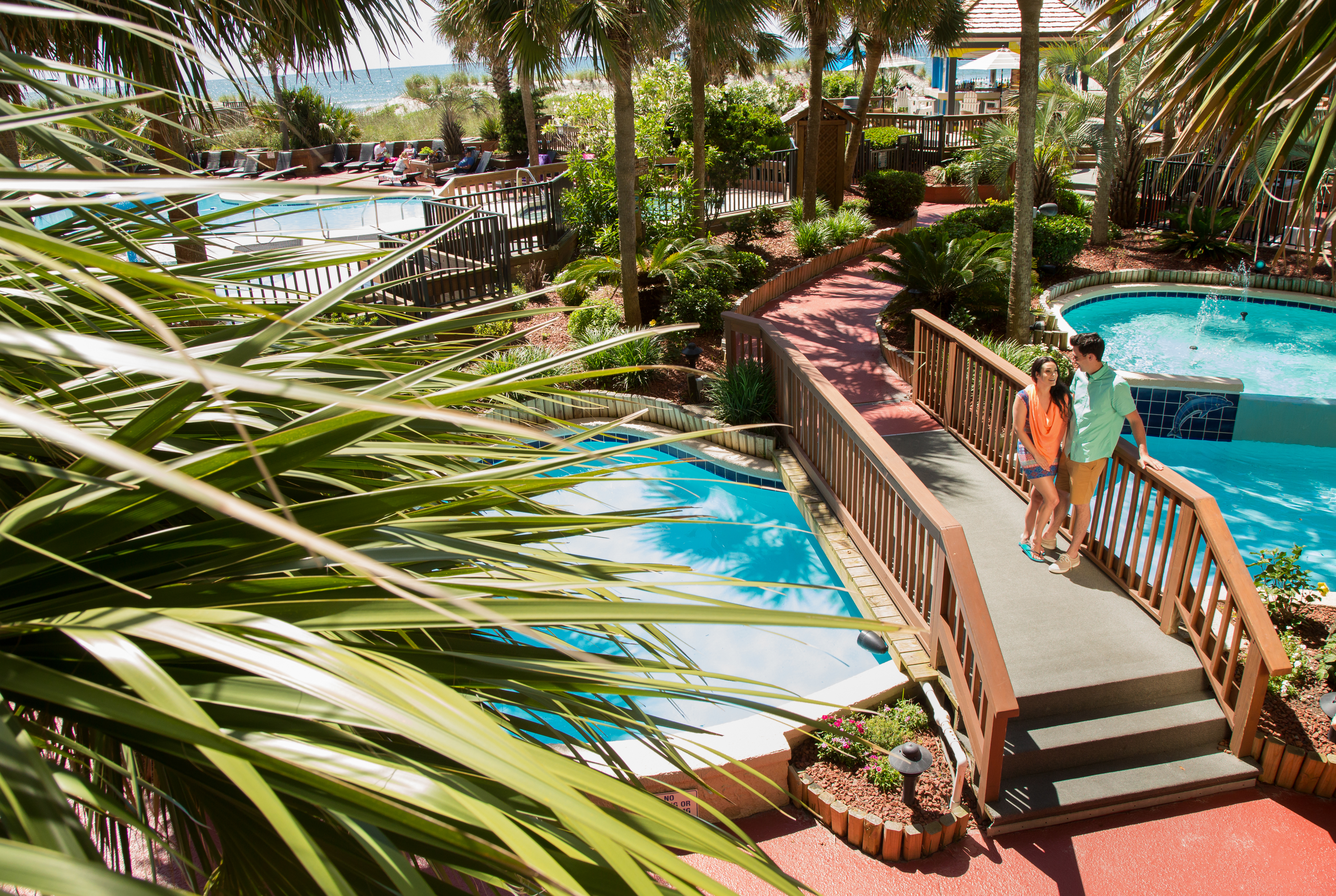 couple standing on beach cove's tropical pool deck