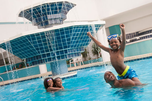 a family swimming in the indoor pool at landmark resort in myrtle beach