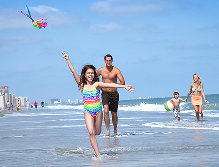 Family on the beach with a kite
